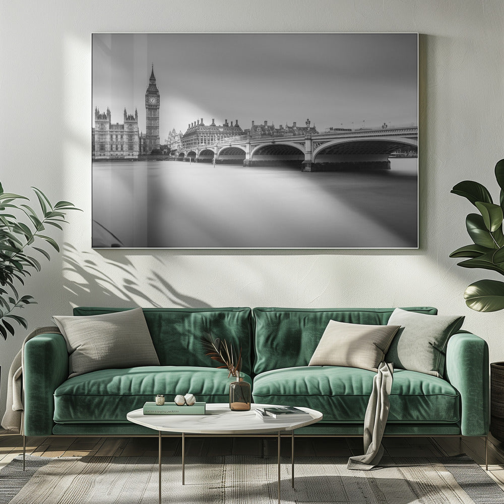 A black and white long-exposure photograph of the Elizabeth Tower (Big Ben) and the Houses of Parliament in London, viewed from across the River Thames. Westminster Bridge stretches across the frame over the smooth, milky water. The image is presented in a silver frame. Artwork