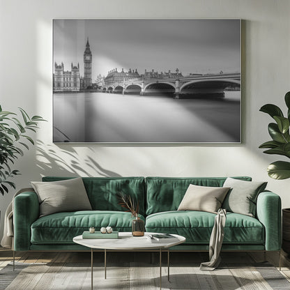 A black and white long-exposure photograph of the Elizabeth Tower (Big Ben) and the Houses of Parliament in London, viewed from across the River Thames. Westminster Bridge stretches across the frame over the smooth, milky water. The image is presented in a silver frame. Artwork