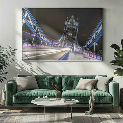 A dramatic, long-exposure night photograph from the deck of London's Tower Bridge, showing vibrant blue support structures curving towards an illuminated stone tower against a dark sky, with bright streaks of light from traffic. Wall Art