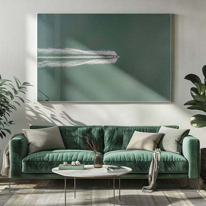 An aerial top-down photograph of a red motorboat speeding across a vast expanse of calm, green water, leaving a long, white, frothy wake behind it. The scene is presented within a simple silver frame. Print