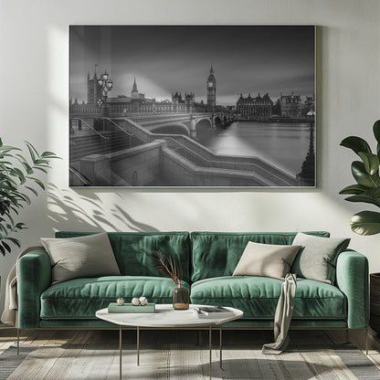 A framed, black and white, long-exposure photograph of the London skyline featuring the Houses of Parliament and the Big Ben clock tower across the River Thames. In the foreground, stone steps lead down towards Westminster Bridge, and the water of the river is smooth and reflective under a dark, cloudy sky. Print