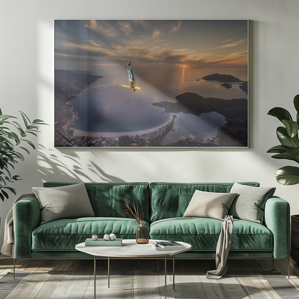 A breathtaking aerial view of a skydiver in a head-down position, freefalling over a vast coastal bay at sunset. The setting sun casts a golden glow over the ocean and clouds, highlighting the islands and coastline below. Decor