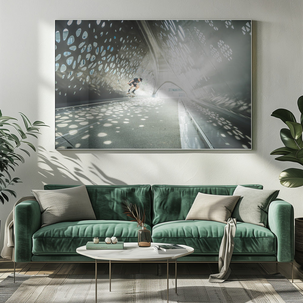 A skateboarder is captured mid-air performing a trick inside a futuristic, metallic tunnel with patterned cutouts that cast dappled light and shadows across the scene, all enclosed within a silver frame. Artwork