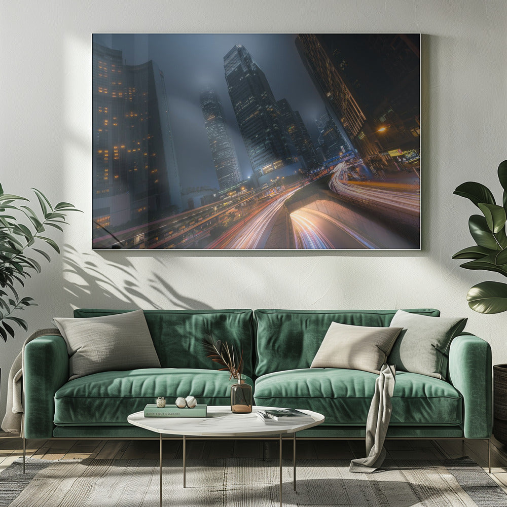 A framed, low-angle photograph capturing a bustling city at night, with towering skyscrapers shrouded in fog. Long-exposure creates vibrant streaks of light from traffic on a multi-level highway, illuminating the dark, modern urban landscape. Wall Art