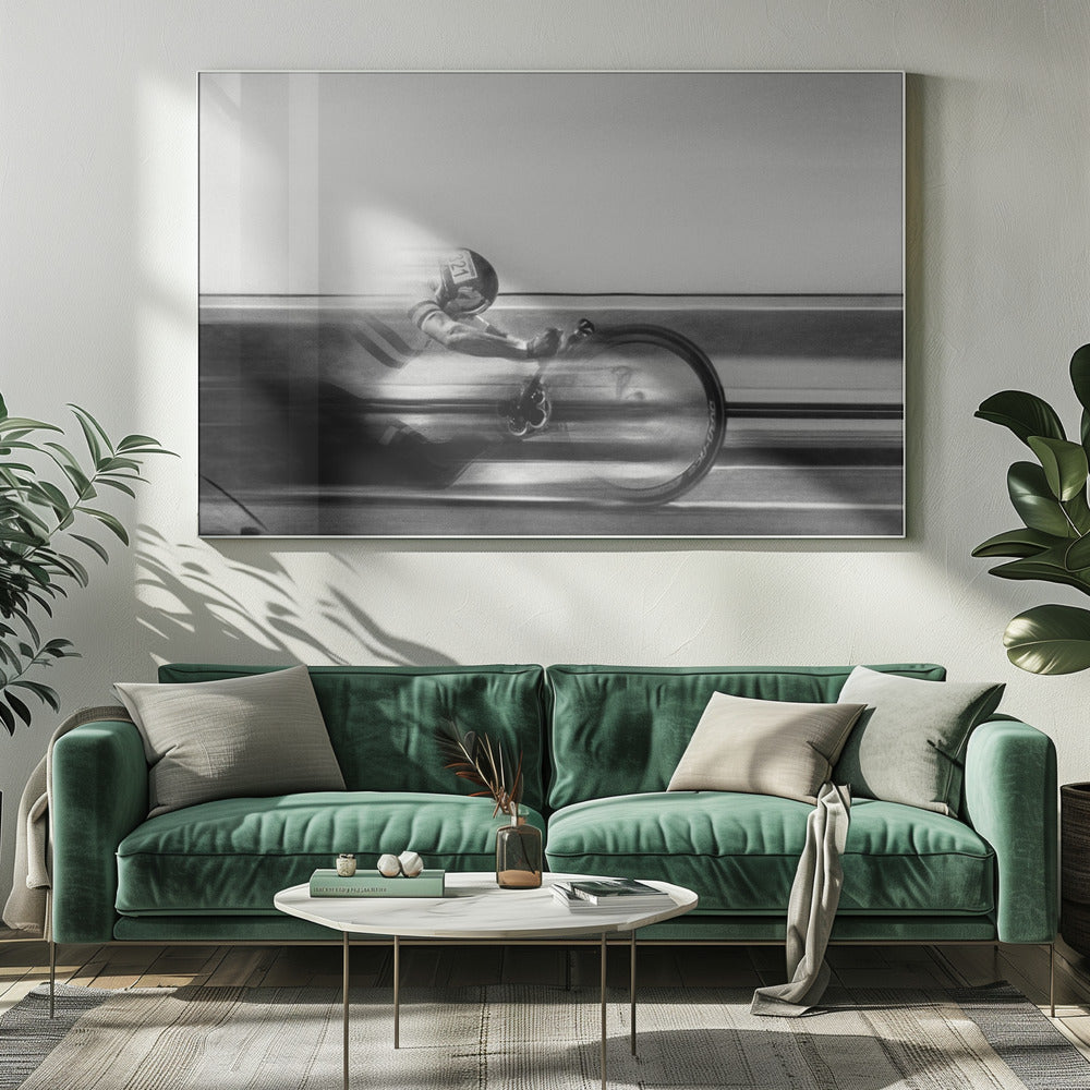 A black and white photograph captured with motion blur, showing a cyclist in an aerodynamic position racing at high speed. The background is blurred into horizontal lines, emphasizing the velocity. The image is enclosed in a silver frame. Wall Art