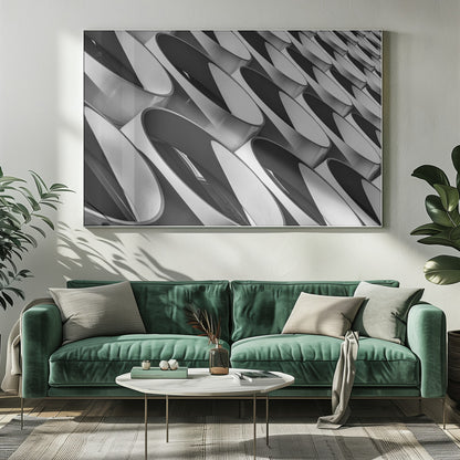 A framed, black and white photograph captures a low-angle, close-up view of a modern building's facade. The image features a repeating pattern of slanted, oval, or teardrop-shaped metallic elements, creating a dynamic interplay of light, shadow, and reflection. Print
