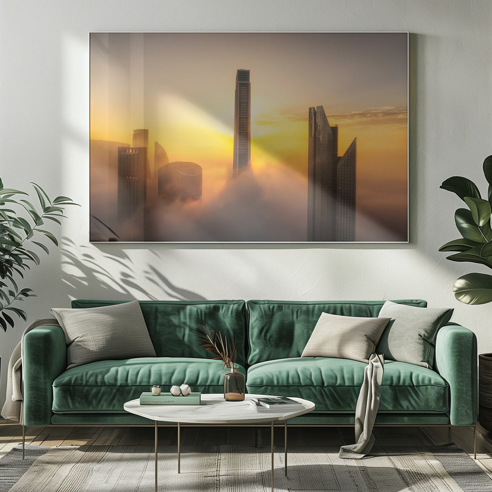 A framed photograph of a modern city skyline with skyscrapers emerging from a thick layer of clouds at sunrise, creating a dramatic and ethereal scene against a golden sky. Wall Art