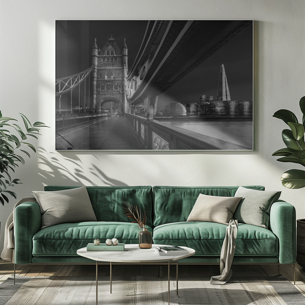 A dramatic, low-angle black and white photograph of London's Tower Bridge at night, taken from the pedestrian walkway. The image showcases the architectural details of the bridge and the illuminated modern city skyline, including The Shard, across the River Thames. Print