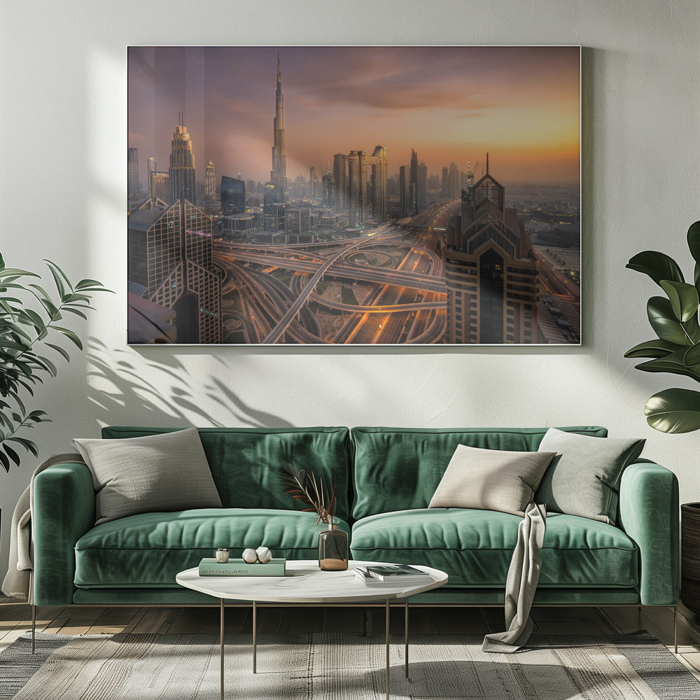 An elevated photograph of the Dubai skyline at sunset, featuring the towering Burj Khalifa against a hazy orange and purple sky. In the foreground, a complex network of illuminated highways and overpasses weaves between modern skyscrapers. Wall Art