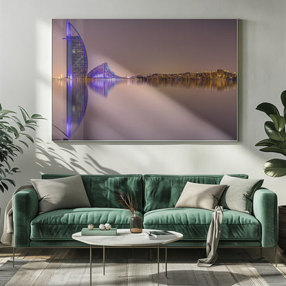 A framed panoramic night photograph of the Dubai skyline featuring the Burj Al Arab hotel lit up in brilliant purple. The city lights and architecture are perfectly reflected in the calm water in the foreground, all under a hazy, dusky sky. Poster