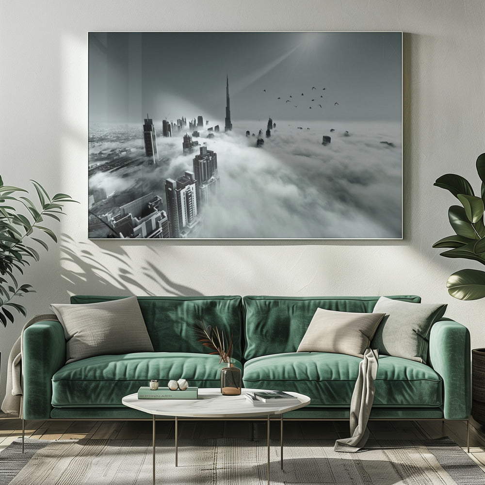 A framed, black and white aerial photograph of the Dubai skyline piercing through a thick layer of clouds. The Burj Khalifa stands prominently in the center, with other skyscrapers emerging from the fog. A flock of birds flies in the sky as a bright sunbeam shines down from the upper right corner. Wall Art