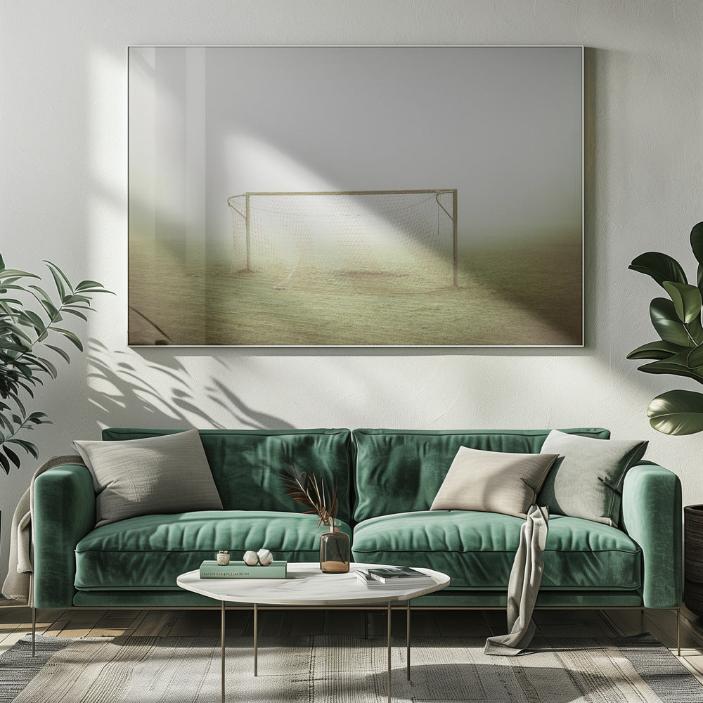 A framed photograph of an empty soccer goal with a net, standing alone on a green grass field enveloped in thick, white fog, creating a minimalist and atmospheric scene. Poster
