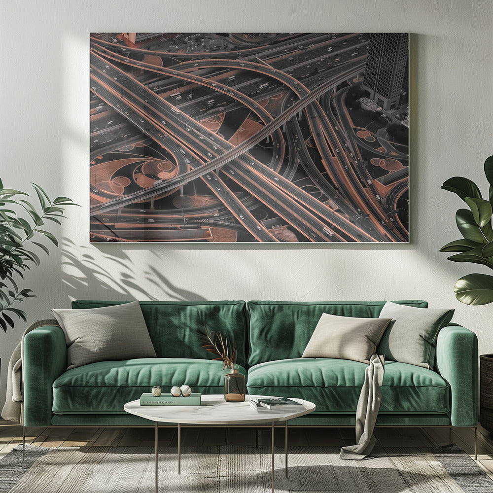 A framed aerial photograph of a sprawling, multi-level highway interchange presented in a selective color style. Dark grey roads weave over and under each other, while the surrounding land is a contrasting copper-brown, creating a dramatic and complex urban pattern. Poster