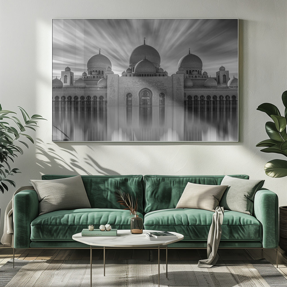 A stunning black and white long-exposure photograph of a grand mosque with multiple domes, reflected perfectly in calm water. The sky above is dramatic, with clouds streaking outwards, and the image is presented in a silver frame. Decor