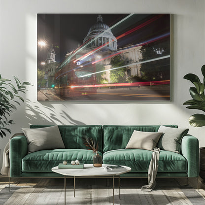 A long-exposure night photograph of a red double-decker bus in London, creating vibrant red and white light trails in front of the illuminated St. Paul's Cathedral. Decor