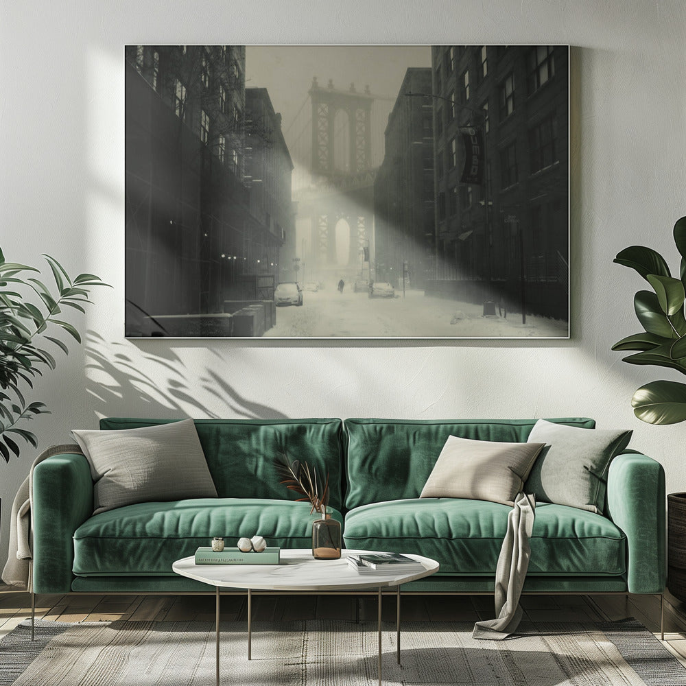 A framed, vintage-style black and white photograph capturing a snowy day in DUMBO, Brooklyn. The view looks down a snow-covered street lined with dark buildings, perfectly framing the Manhattan Bridge in the foggy distance. A few cars are parked along the street, and snow is visibly falling, creating a quiet, atmospheric winter scene. Decor