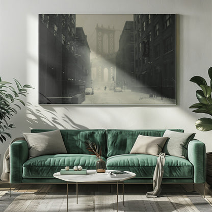 A framed, vintage-style black and white photograph capturing a snowy day in DUMBO, Brooklyn. The view looks down a snow-covered street lined with dark buildings, perfectly framing the Manhattan Bridge in the foggy distance. A few cars are parked along the street, and snow is visibly falling, creating a quiet, atmospheric winter scene. Decor