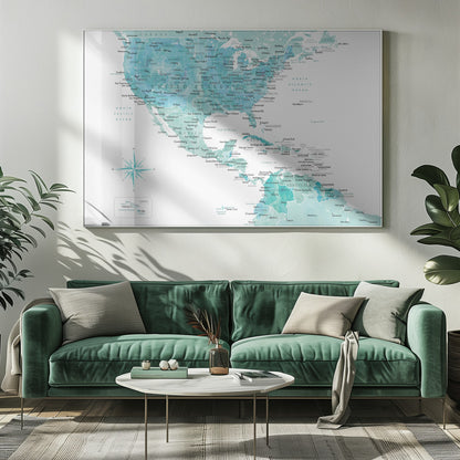 A decorative map of North, Central, and South America in a grey frame. The map has a watercolor texture in shades of blue and teal on a white background, with countries and major cities labeled in a dark font. Print