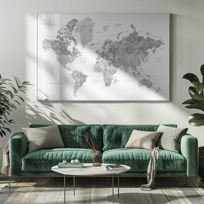 A framed, modern world map presented in a monochrome palette of black, white, and various shades of gray. The landmasses feature a detailed, textured design, set against a clean white background for the oceans. A compass rose is visible in the top left corner. The map is enclosed within a simple, light gray frame. Poster