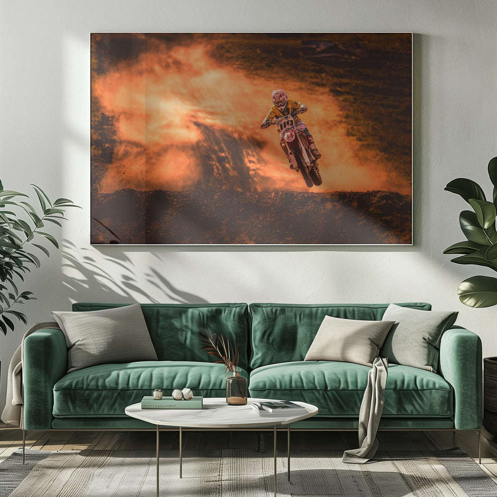 An action-packed photo of a motocross rider in mid-air, jumping their dirt bike over a mound of earth. A large cloud of orange dust billows behind them, creating a dramatic and fiery background. Wall Art