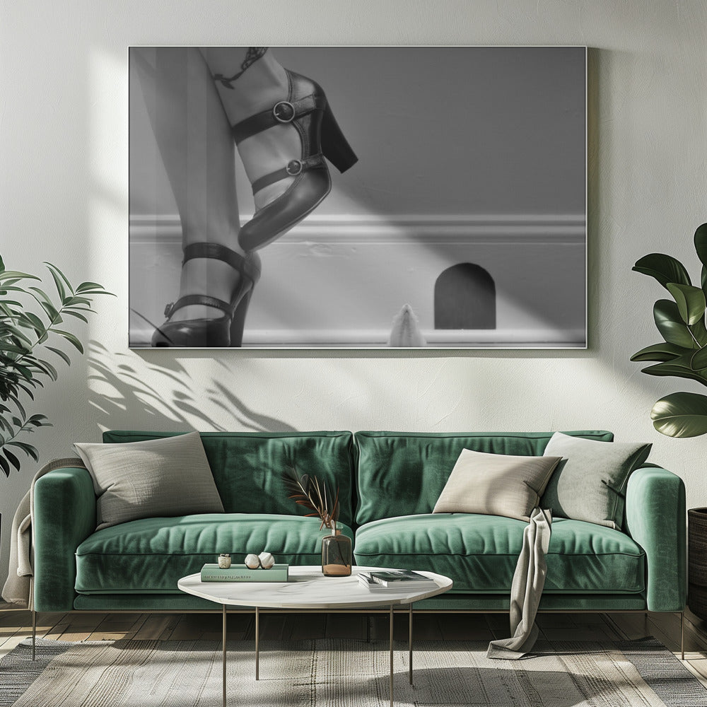 A black and white photograph showing the lower legs and feet of a woman wearing black high-heeled Mary Jane shoes. A tiny white mouse stands on its hind legs near a cartoonish mouse hole in the baseboard, looking up at the woman. Artwork