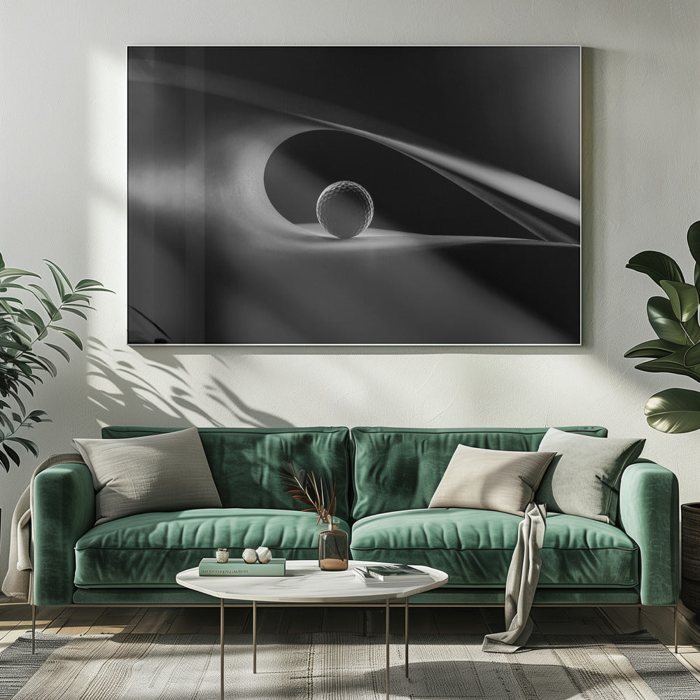 An artistic black and white photograph of a golf ball resting inside the gentle curve of a dark, abstract shape, creating a minimalist and dramatic composition with strong light and shadows. Poster