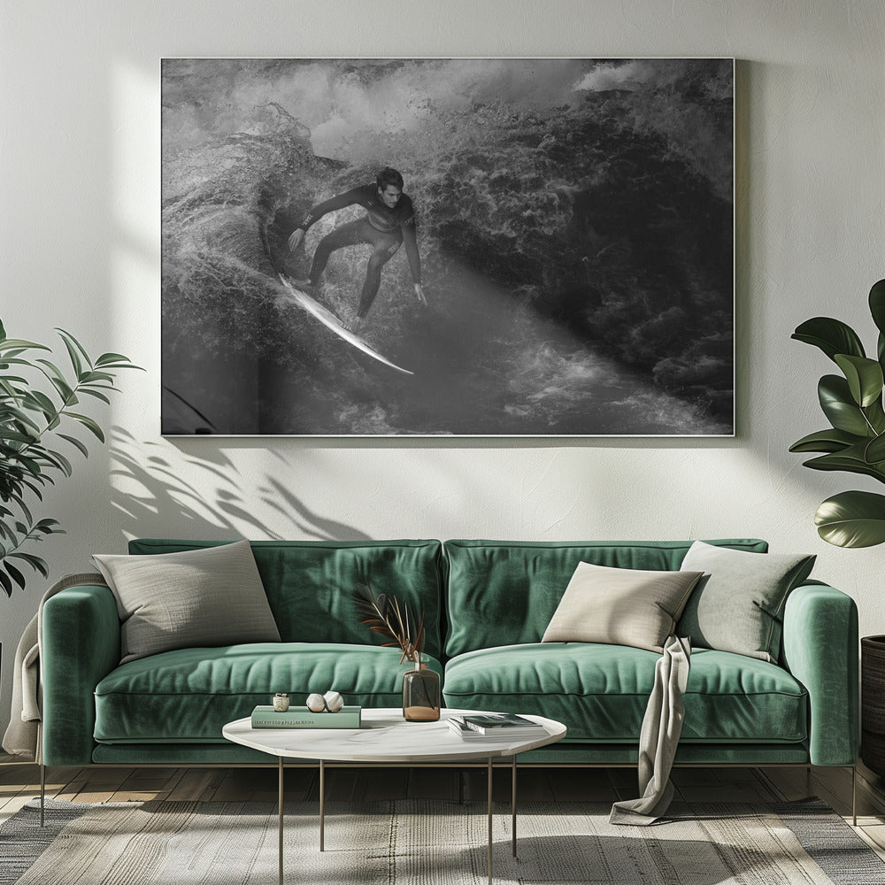 A dramatic black and white photograph of a surfer in a wetsuit skillfully riding down the face of a large, turbulent wave. The image is enclosed in a silver frame. Wall Art