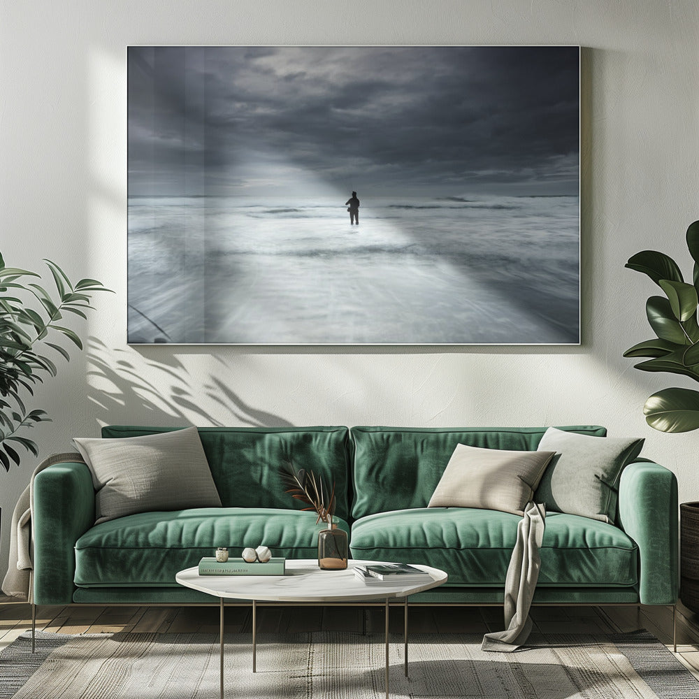 A moody, long-exposure photograph of a silhouetted fisherman standing in the churning white surf of the ocean under a dark, stormy sky, presented in a silver frame. Wall Art