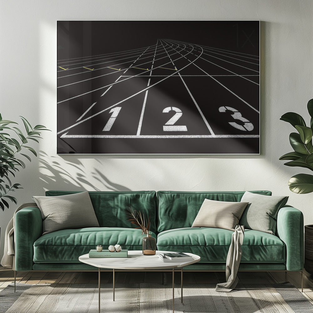 A framed, high-contrast graphic of a black running track from a low-angle perspective at the starting line. White lines delineate the lanes, with the numbers 1, 2, and 3 stenciled in the foreground. The track curves and recedes into the distance, creating a strong sense of perspective. Decor