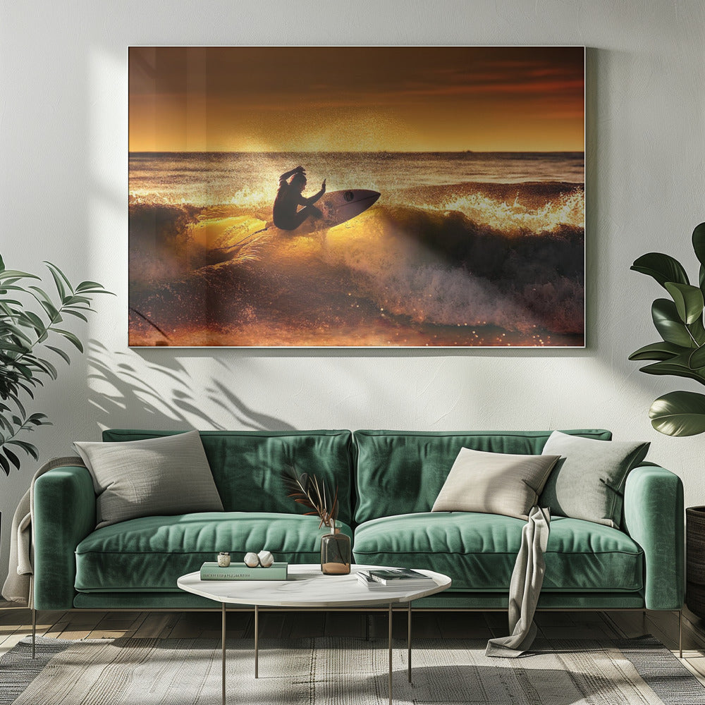 A silhouetted surfer carves a turn on a sun-kissed wave during a vibrant orange sunset, with golden light reflecting off the water and sea spray. Wall Art