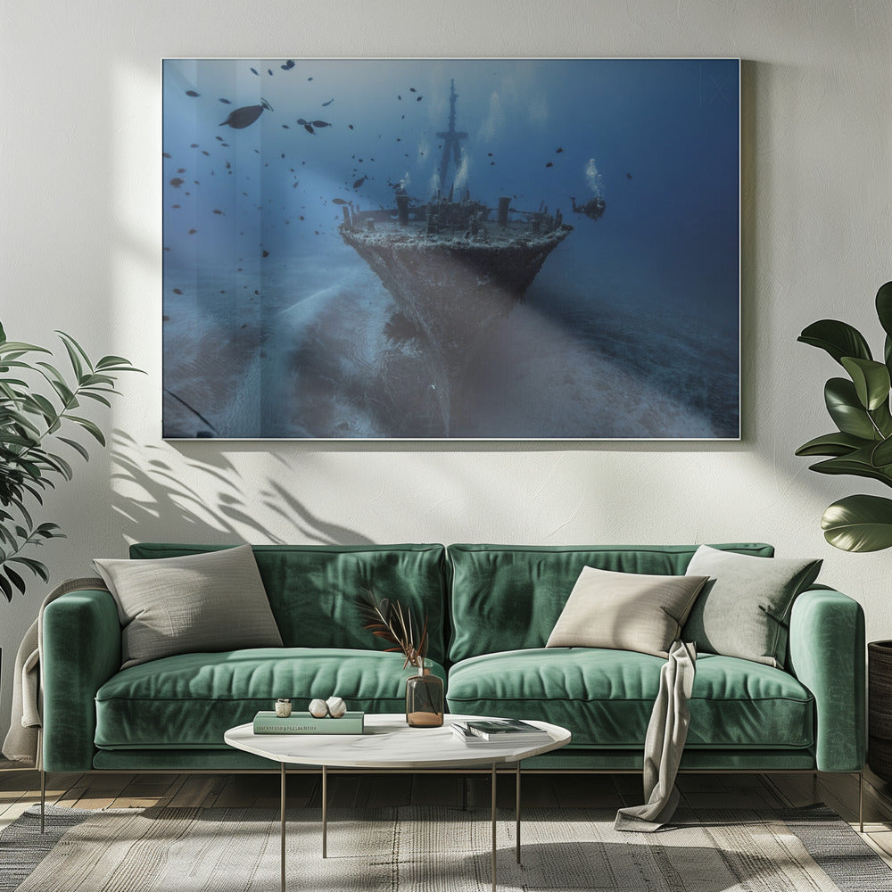 An underwater photograph of a large, sunken shipwreck resting on the sandy ocean floor. Two scuba divers are exploring the wreck, surrounded by schools of small fish in the deep blue water, with light filtering down from the surface. Print