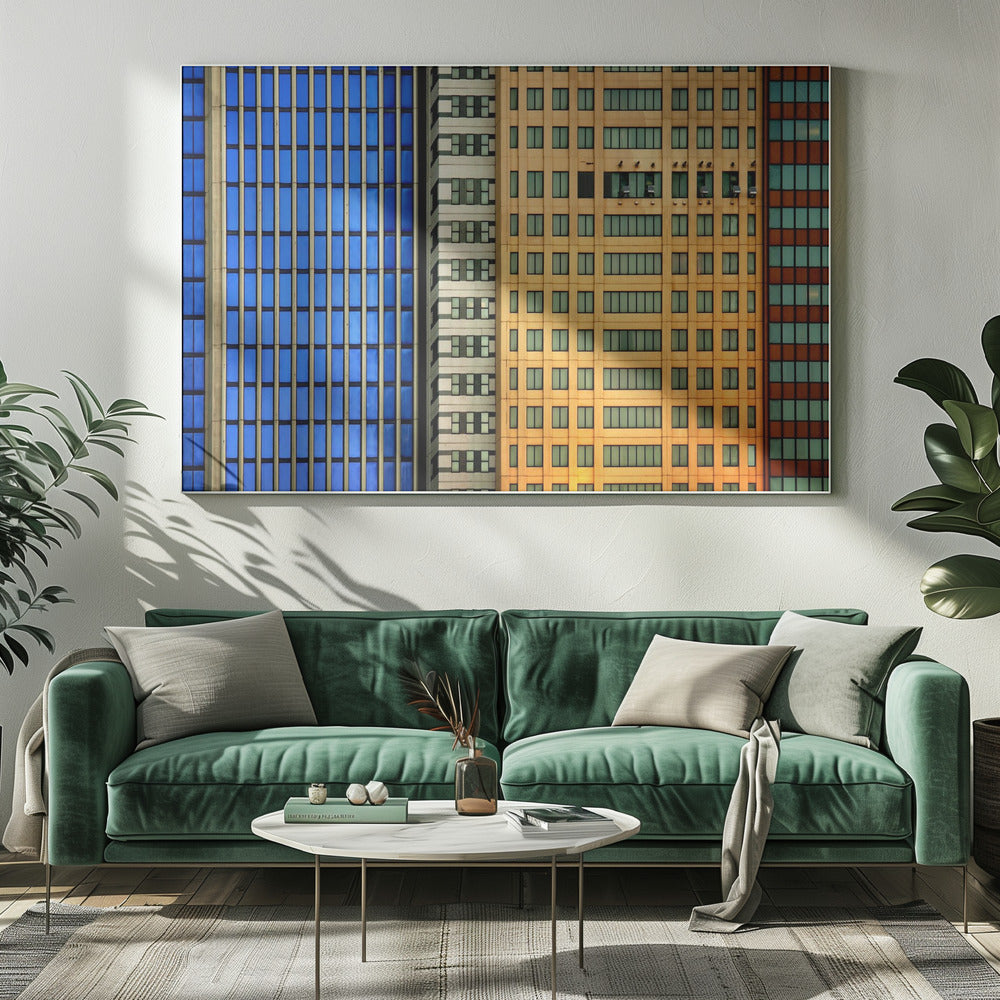 An abstract architectural photograph showing the colorful gridded facades of three adjacent skyscrapers, featuring a blue-windowed building, a white building, and a yellow building, all contained within a silver frame. Wall Art