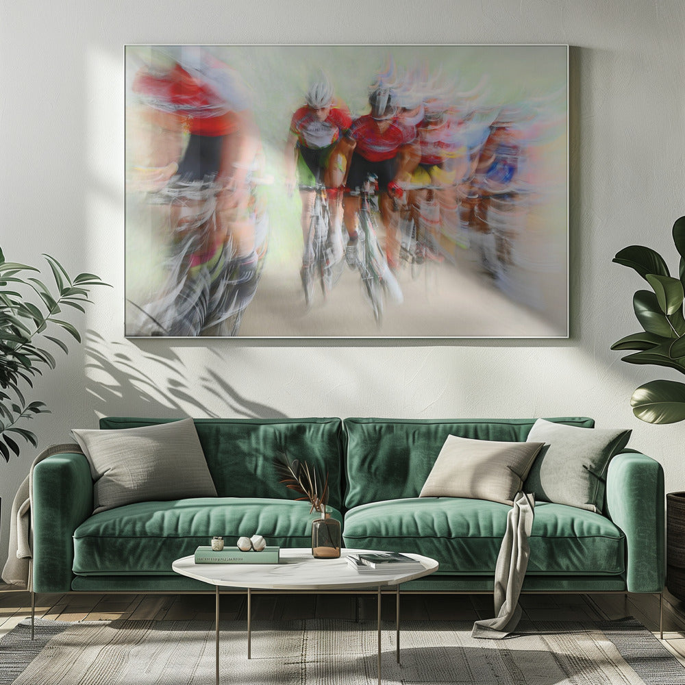 An abstract photograph of a group of cyclists in a race, captured with motion blur to create a dynamic sense of speed. The riders' red jerseys and the green background are streaked together, with a silver frame surrounding the image. Artwork