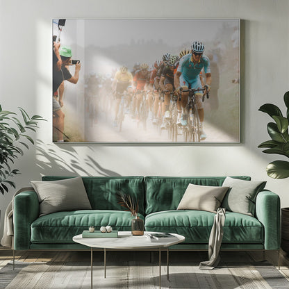 A framed photograph of a peloton of professional cyclists racing down a dusty dirt road. The lead cyclist is in sharp focus, wearing a bright turquoise uniform and a helmet, with other racers in yellow and red jerseys blurred behind him. A spectator on the left is taking a photo with a smartphone. Poster