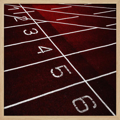A framed, high-angle photograph of a deep red running track, showing the white lines and numbers for lanes one through six creating a grid-like pattern. Poster