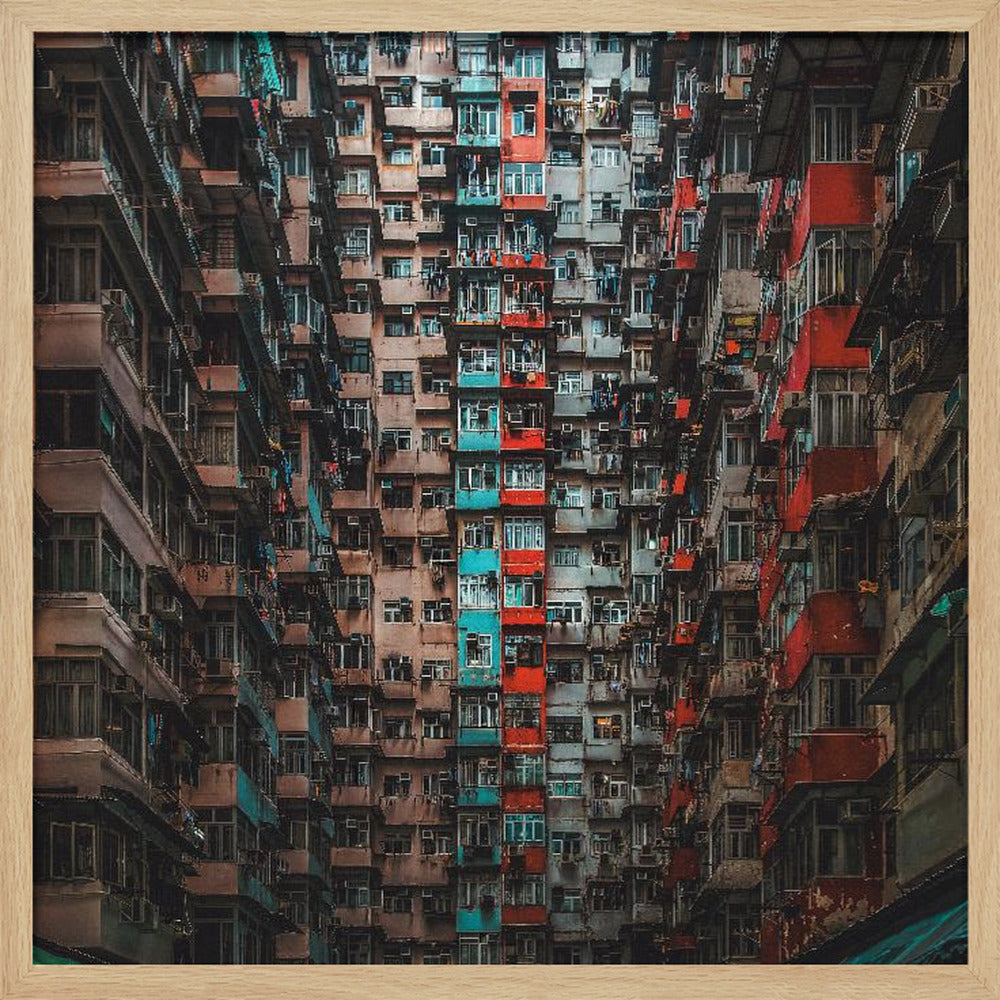 A framed, low-angle photograph looking up at densely packed, weathered apartment buildings that create a canyon-like view, with some facades painted in vibrant red and teal. Wall Art