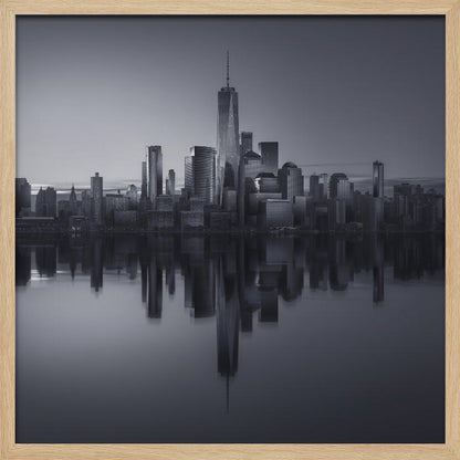 A framed, moody black and white photograph of the Lower Manhattan skyline, featuring the One World Trade Center, with a perfect, still reflection of the skyscrapers in the water below. Decor