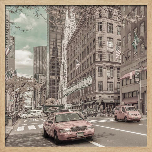 A framed photograph of a busy New York City street with a vintage, sepia-toned filter. Two cars, one in the foreground and one in the midground, are selectively colored a dusty pink, contrasting with the muted tones of the surrounding skyscrapers, American flags, and pedestrians. The sky is a pale teal color. Poster