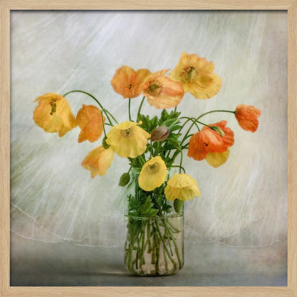 A soft-focus still life photograph of a bouquet of yellow and orange poppies in a clear glass jar, set against a delicate, light green textured background, all enclosed in a light wood frame. Print