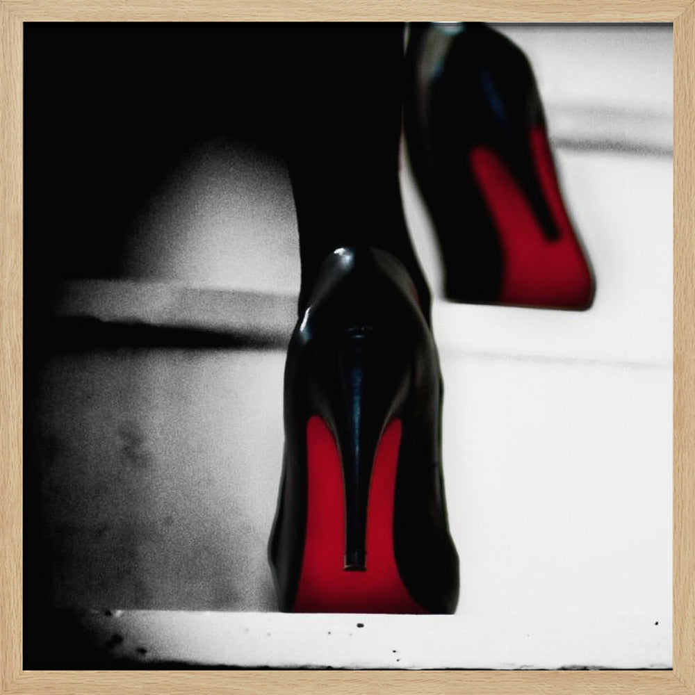 A dramatic, low-angle, black and white photograph focusing on the back of a person wearing glossy black high heels with vibrant red soles, all set within a light wood frame. Artwork