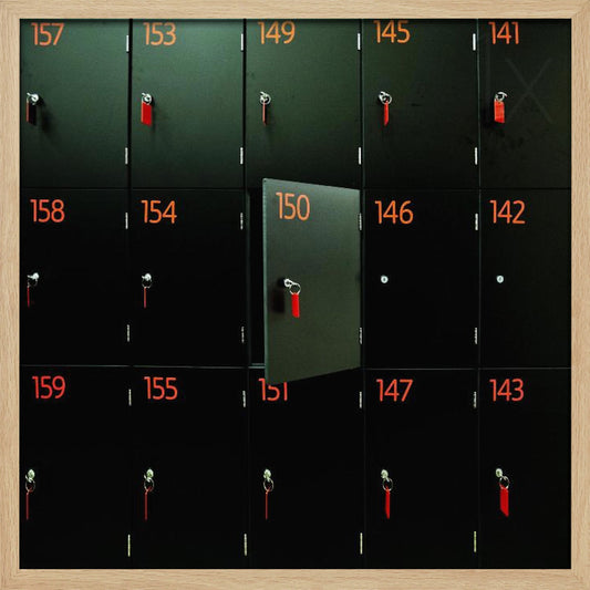 A head-on shot of a grid of black lockers inside a light wood frame. Each locker has a bright orange number and a key with a red tag. Locker number 150 is open, creating a focal point in the otherwise uniform pattern. Wall Art