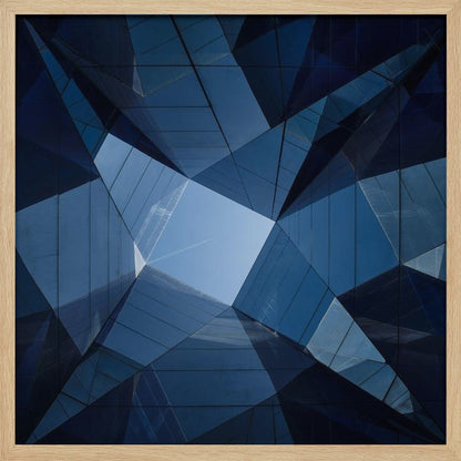 A framed, low-angle photograph looking up towards the sky, surrounded by the reflective blue glass facades of modern buildings which create a kaleidoscopic, geometric pattern. Print