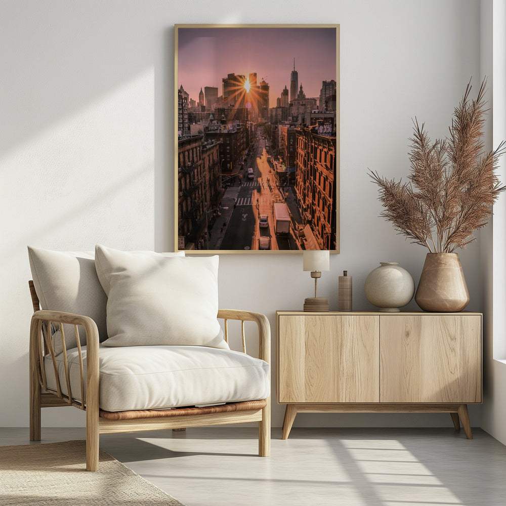 A high-angle view of a New York City street at sunset, with the sun bursting between skyscrapers and casting long golden shadows over the buildings and traffic below. Decor