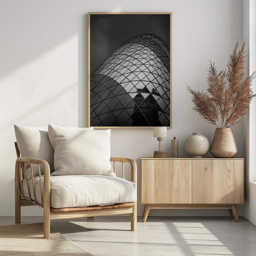 A framed, low-angle, black and white photograph of the curved, glass-paneled facade of a modern skyscraper, creating a dynamic pattern of reflective diamonds against a dark, moody sky. Artwork