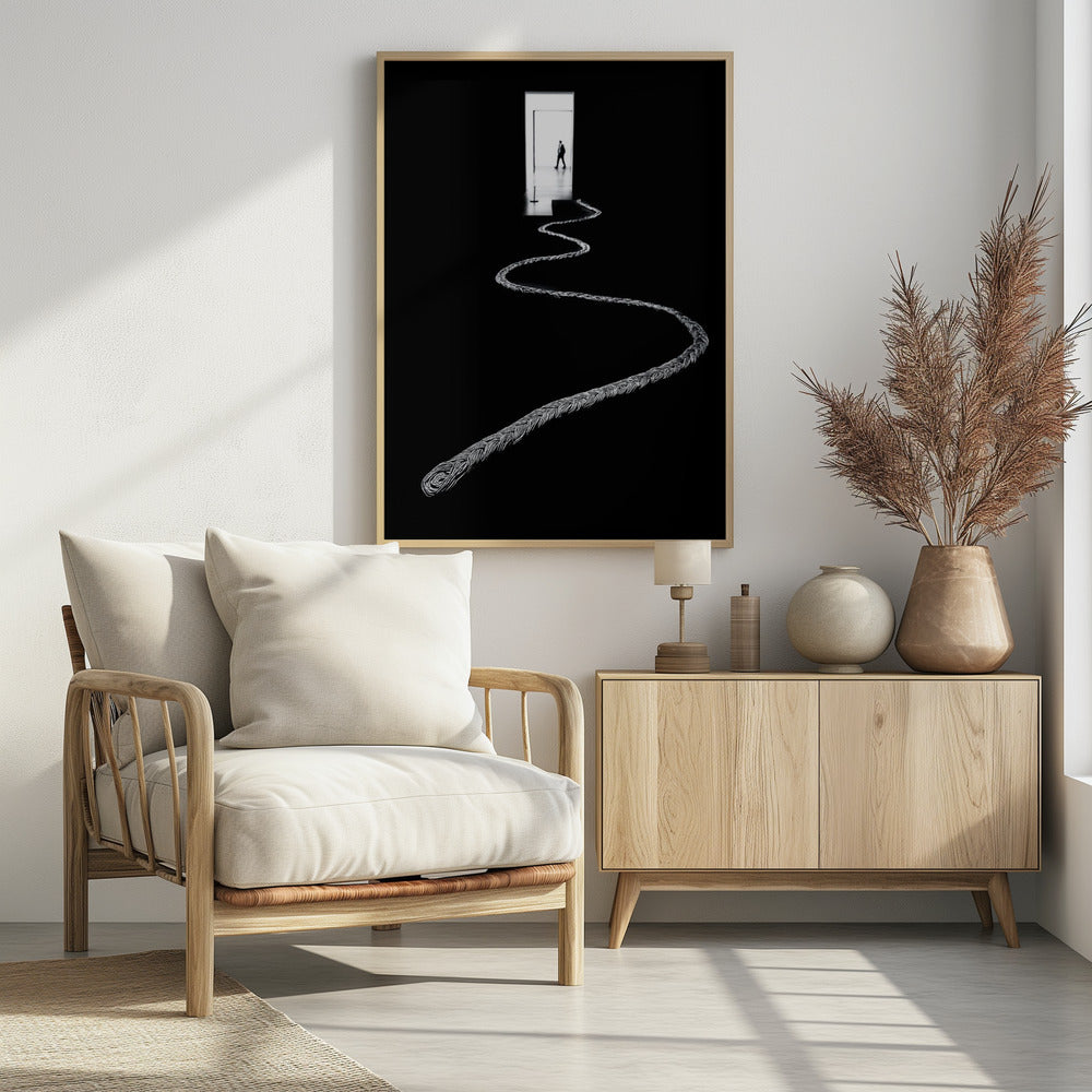 A high-contrast, black and white photograph of a thick, silver, braided rope winding across a black floor, leading towards a brightly lit doorway in the distance where a silhouetted man is walking away. Wall Art