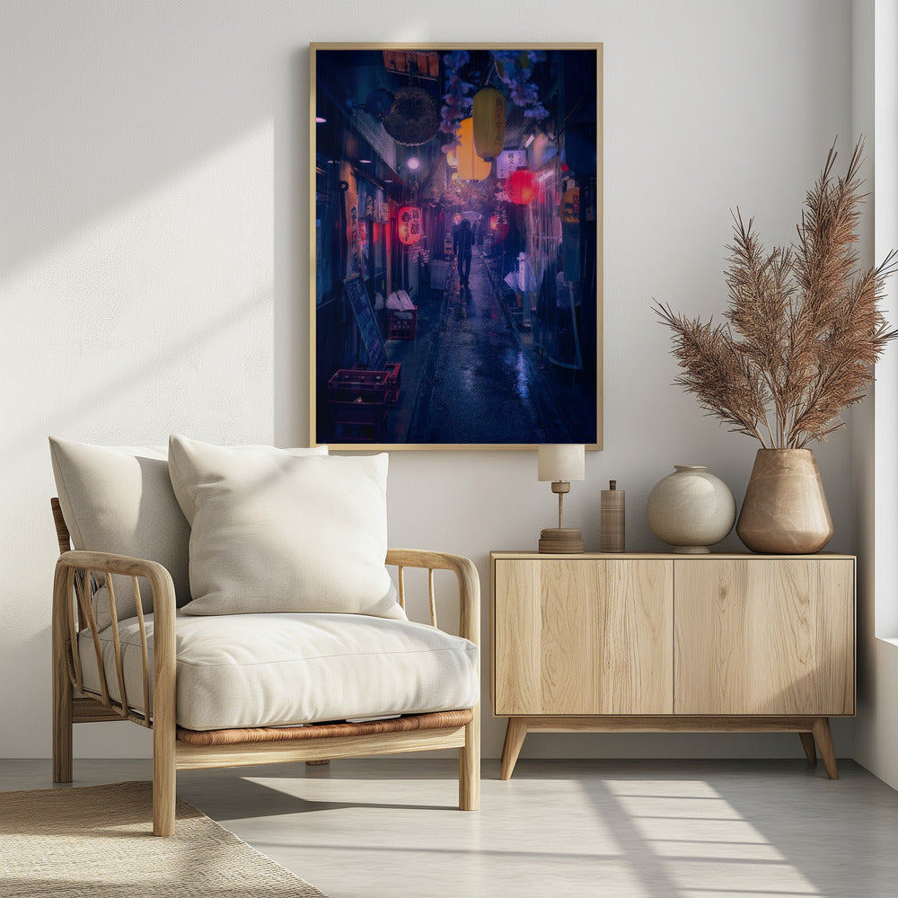 A lone figure walks down a narrow, rain-slicked Japanese alley at night. Colorful paper lanterns hang overhead, casting warm orange and red light that reflects on the wet ground, contrasting with the cool blue tones of the evening. Wall Art