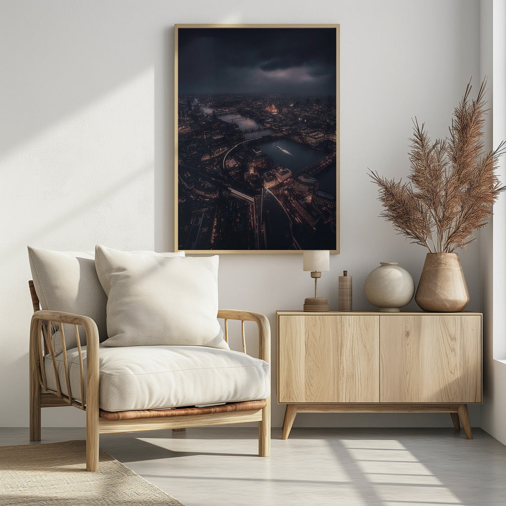 An aerial photograph of London at night from a high vantage point, overlooking the winding River Thames illuminated by the golden glow of city lights under a dark, dramatic, and cloudy sky. Wall Art