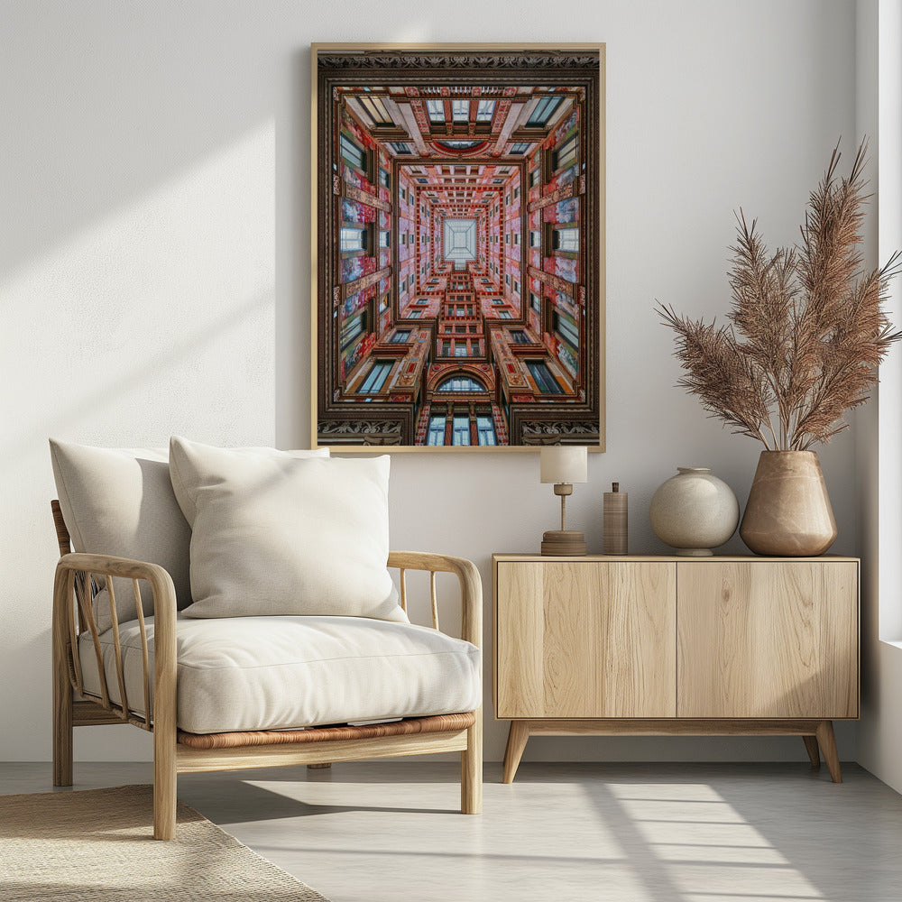 A symmetrical, worm's-eye view looking up through the center of an ornate, multi-story courtyard. The red and gold walls are covered in intricate details and frescoes, receding into the distance towards a square glass skylight. The entire artwork is presented within a decorative dark brown frame. Artwork