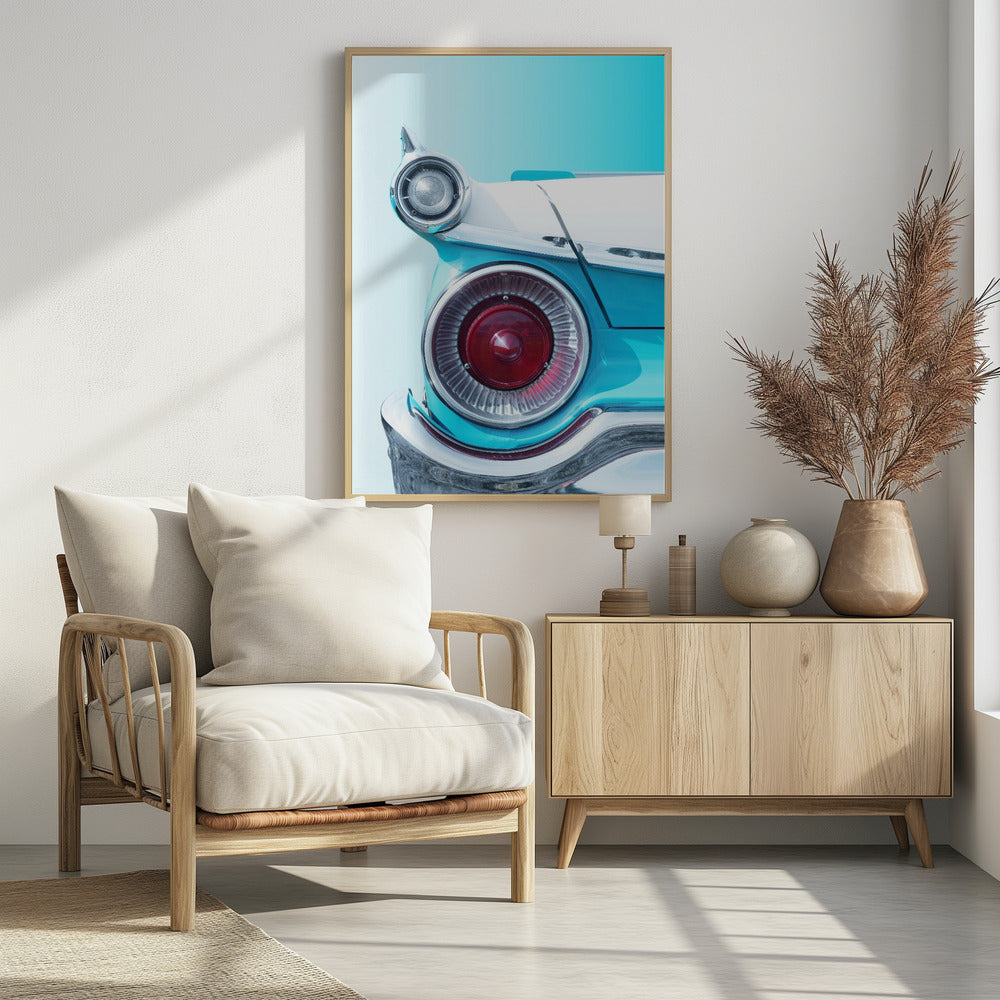 A close-up, framed photograph of the tail fin of a vintage turquoise and white car. The focus is on the large, round, red taillight and the smaller chrome-encased light on the fin, set against a solid light blue background. Poster