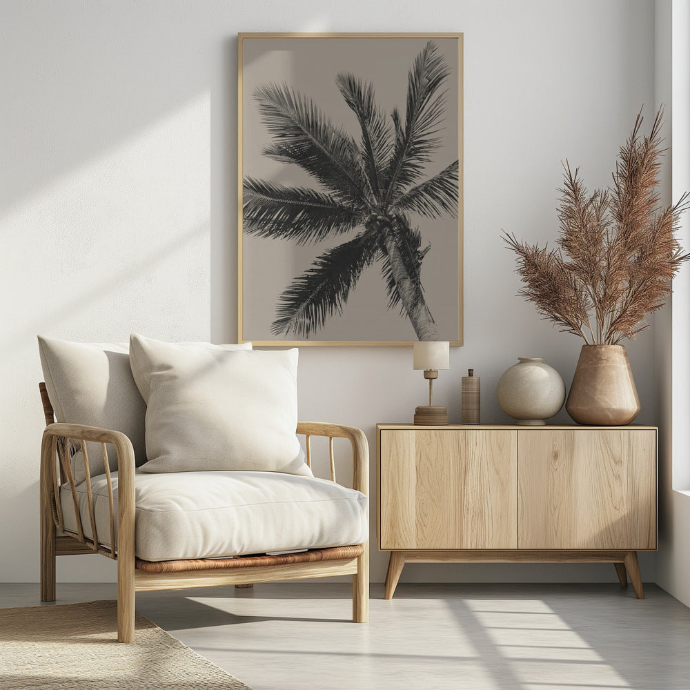 A low-angle, monochrome photograph of a palm tree against a solid light beige sky. The image is framed in black, and the palm fronds spread out across the frame, with a few coconuts visible at the top of the trunk. Poster